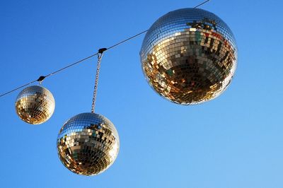 Low angle view of lighting equipment hanging against clear sky