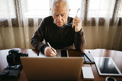 Senior photographer working with laptop