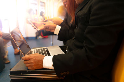 Midsection of woman using smart phone at table