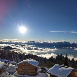 Scenic view of snow covered houses and trees against sky