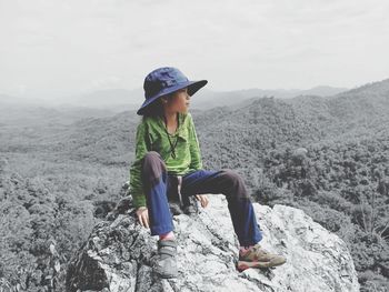 Rear view of boy sitting on mountain