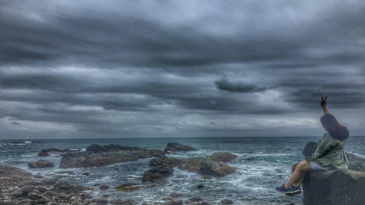 sea, cloud - sky, real people, sky, horizon over water, one person, water, nature, leisure activity, lifestyles, outdoors, beach, beauty in nature, scenics, men, day, standing, wave, women, storm cloud, sitting, full length, people