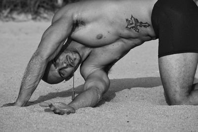 High angle view of shirtless boy on sand at beach