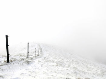 Scenic view of snow covered field against sky