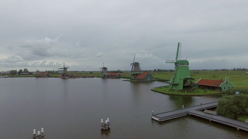 Factory by river against sky