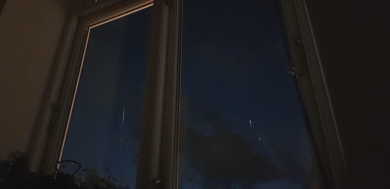 LOW ANGLE VIEW OF GLASS WINDOW AT NIGHT