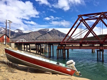 Boat moored at lakeshore by bridge