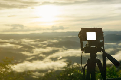 Low angle view of camera against sky during sunset