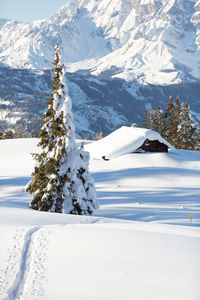 Winter wonderland in austrian alps. snow tracks to the old alpine hut. selective focus
