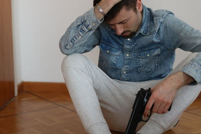 Midsection of man sitting at home