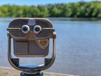 Close-up of coin-operated binoculars against sea