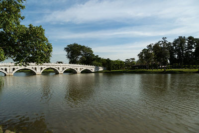 Arch bridge over river against sky