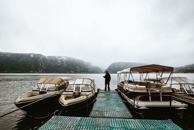 Rear view of man standing on lake against sky