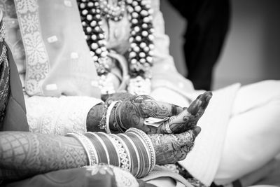 Midsection of bride holding wedding dress
