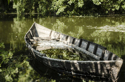 Abandoned boat floating on lake