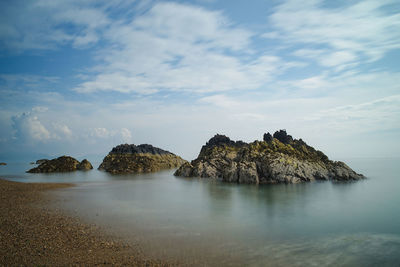 Rocks in sea against sky