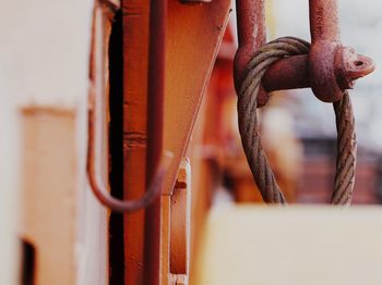 Close-up of rusty chain hanging on railing