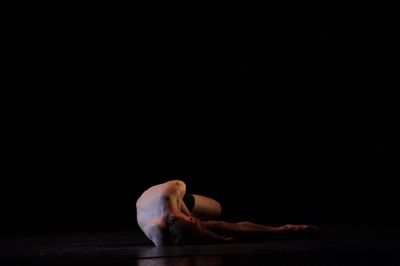 Midsection of man dancing against black background