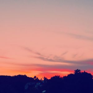 Low angle view of silhouette trees against dramatic sky