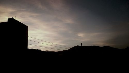 Low angle view of silhouette building against sky