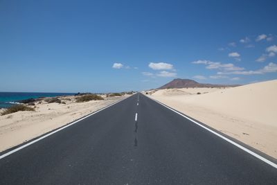 Road leading towards sea against sky