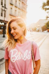 Portrait of smiling woman standing on street in city