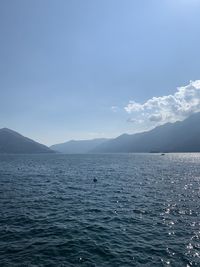 Scenic view of sea and mountains against sky