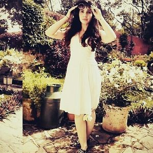 Beautiful young woman standing by leaves against tree