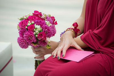 Midsection of woman with pink roses