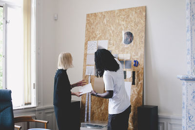 Multi-ethnic business people discussing over charts in creative office