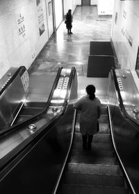 Rear view of man on escalator at railroad station