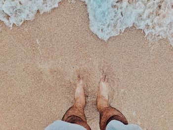 Low section of person standing on beach