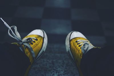 Low section of person standing on yellow shoes