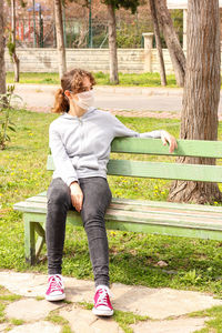 Full length of woman sitting on bench