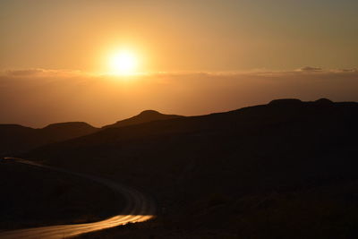 Scenic view of silhouette mountains against sky during sunset