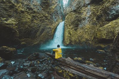 Rear view of man overlooking waterfall