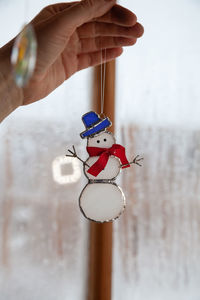 Close-up of hand holding toy snowman 