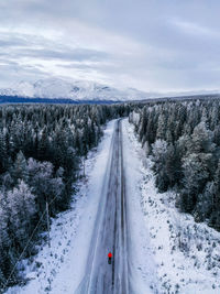 High angle view of road amidst snow covered trees against sky