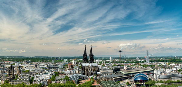 High angle view of city buildings against cloudy sky