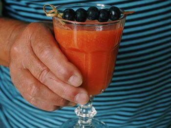 Close-up of hand holding glass of juice