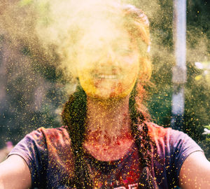 Young woman playing with powder paint during holi