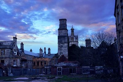 Buildings against cloudy sky at sunset