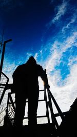 Low angle view of silhouette man photographing against sky