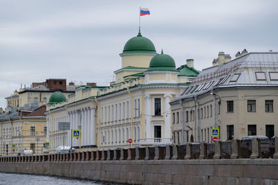 Buildings in city against cloudy sky