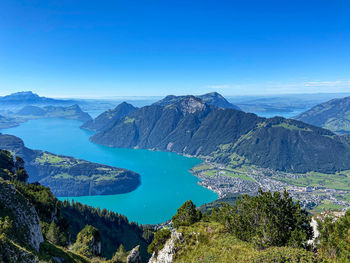 High angle view of lake and mountains against blue sky