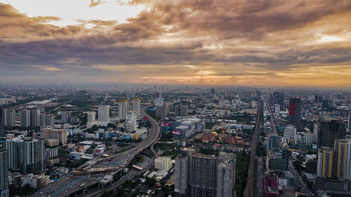 High angle view of illuminated cityscape against sky during sunset