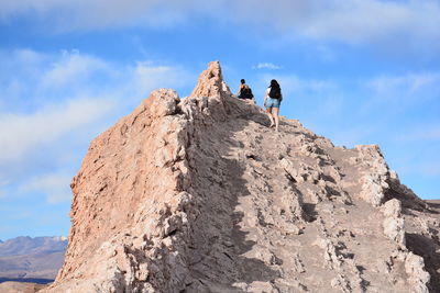 Low angle view of people on mountain against sky