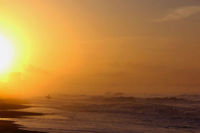 Scenic view of sea against orange sky