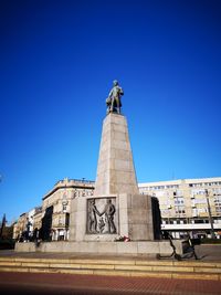 Low angle view of statue against blue sky