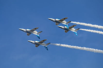 Low angle view of airshow against sky